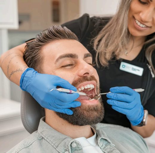Dentist examining a smiling male patient during a check-up